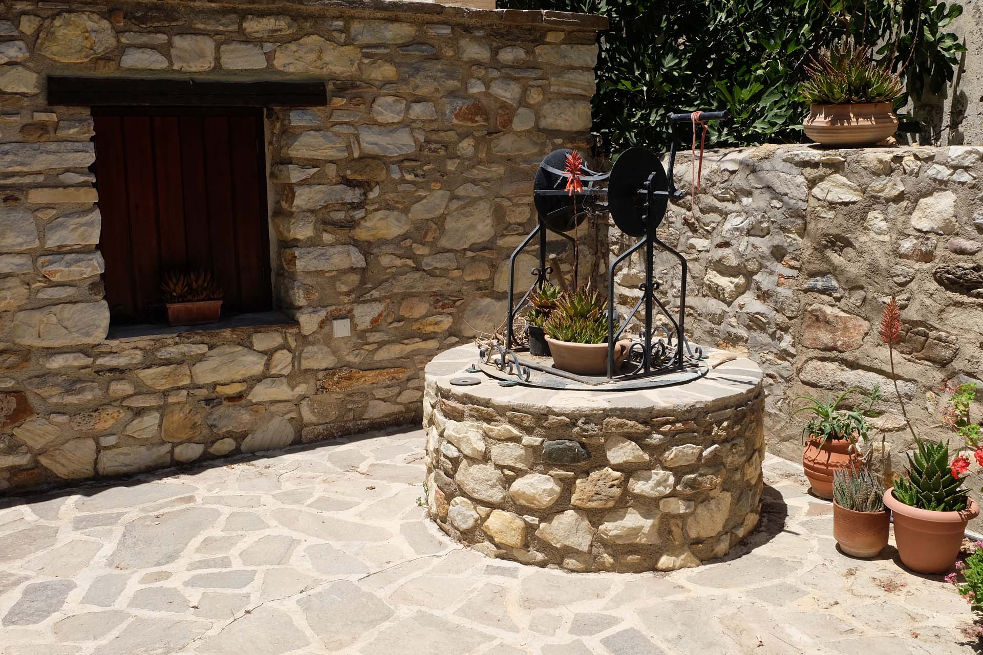 Uriger gemauerter Brunnen auf einem kleinen Platz im Dorf